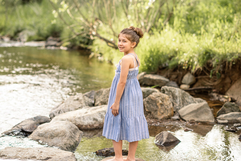 Young girl stepping across rocks in creek in York PA
