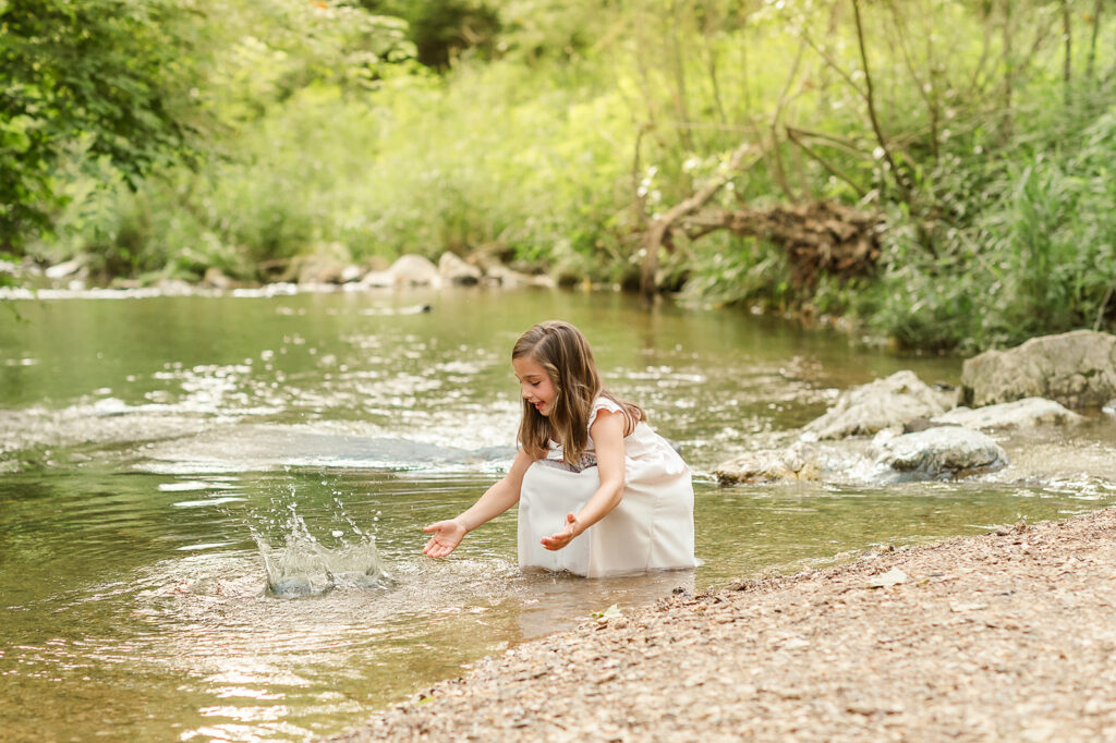 Young girl splashing water in creek during session at Mill Creek Preserve in York PA