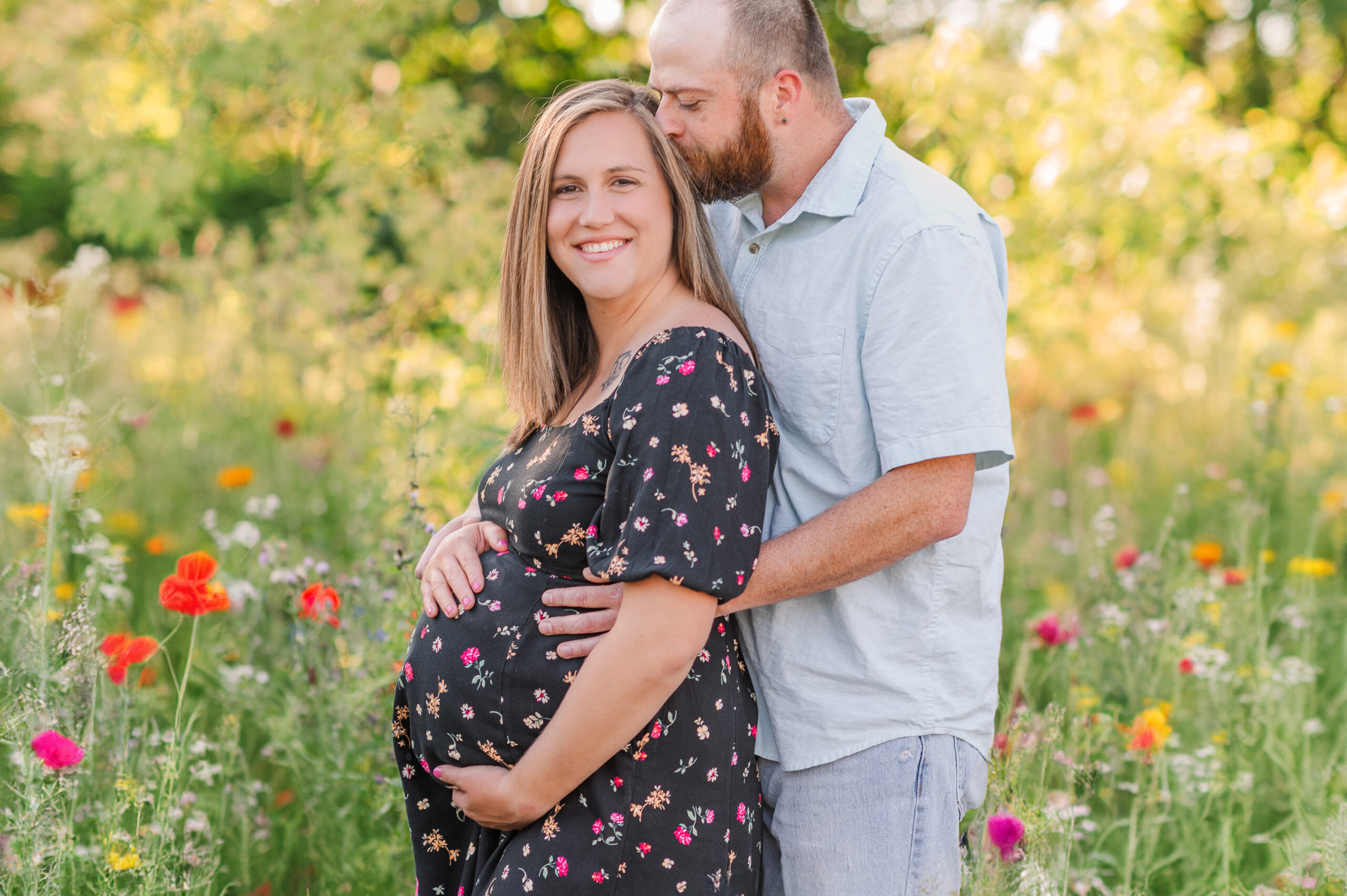 Mother and father posing in a wild flower field by maternity photographer york harrisburg lancaster pa