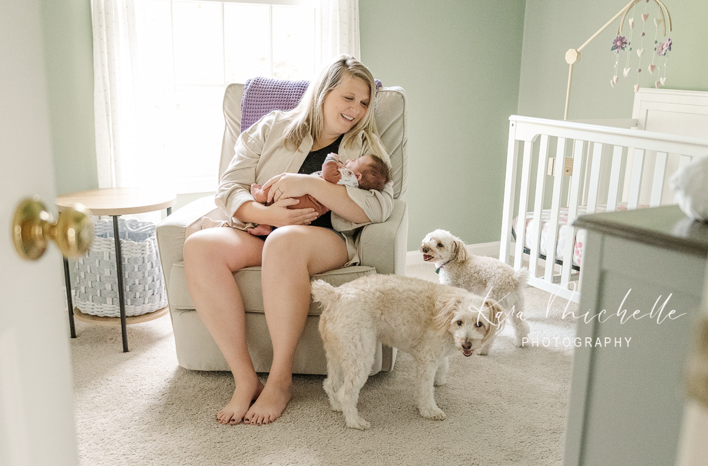 Mother sitting with newborn and her pets by photographer york pa