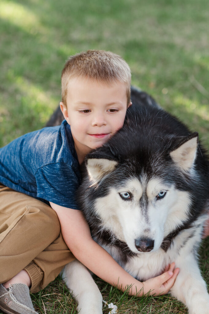Young boy cuddling husky dog during a family photography session in York Pennsylvania