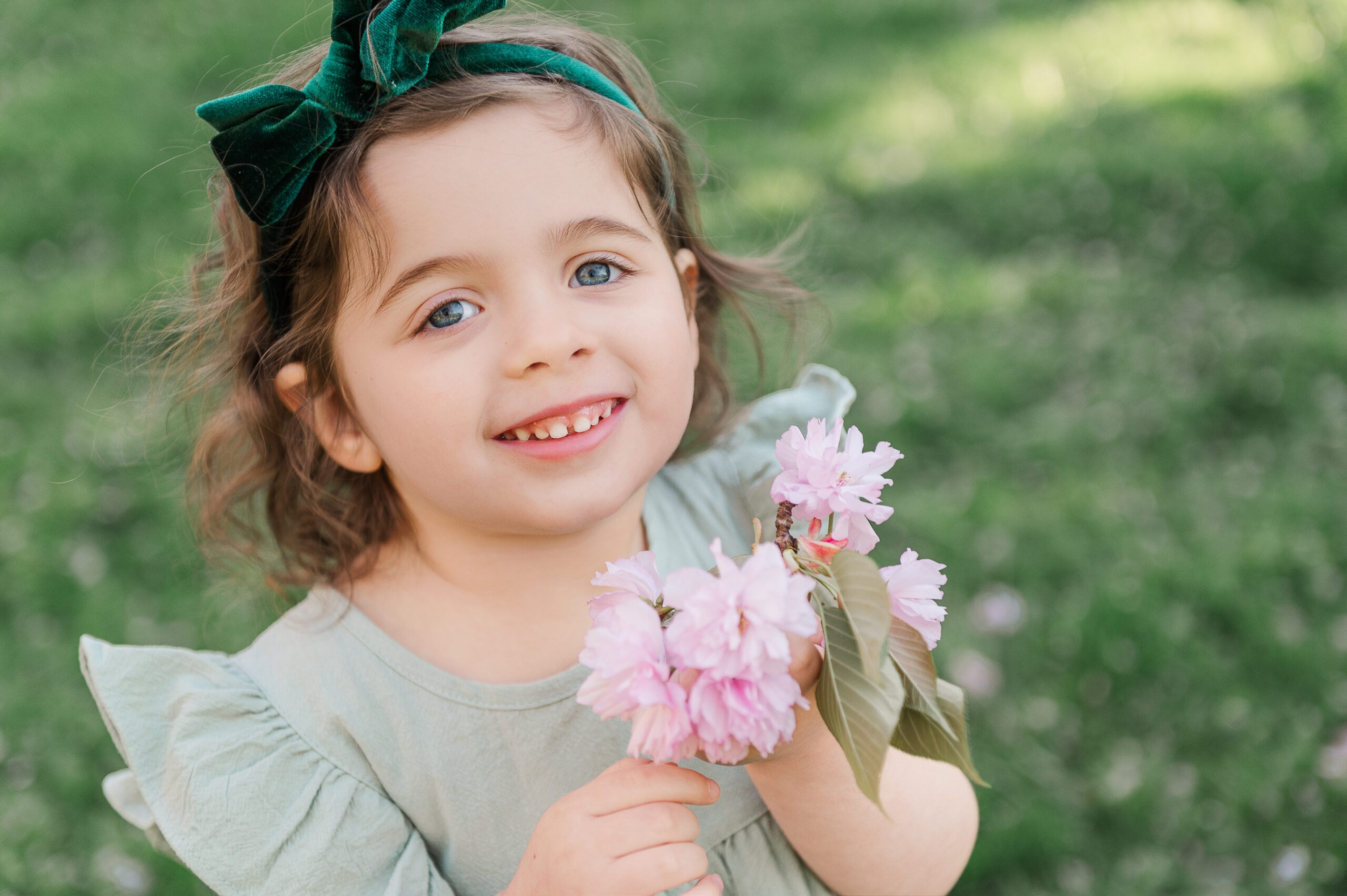 Little girl holding cherry blossom during spring mini session lancaster pa photographer