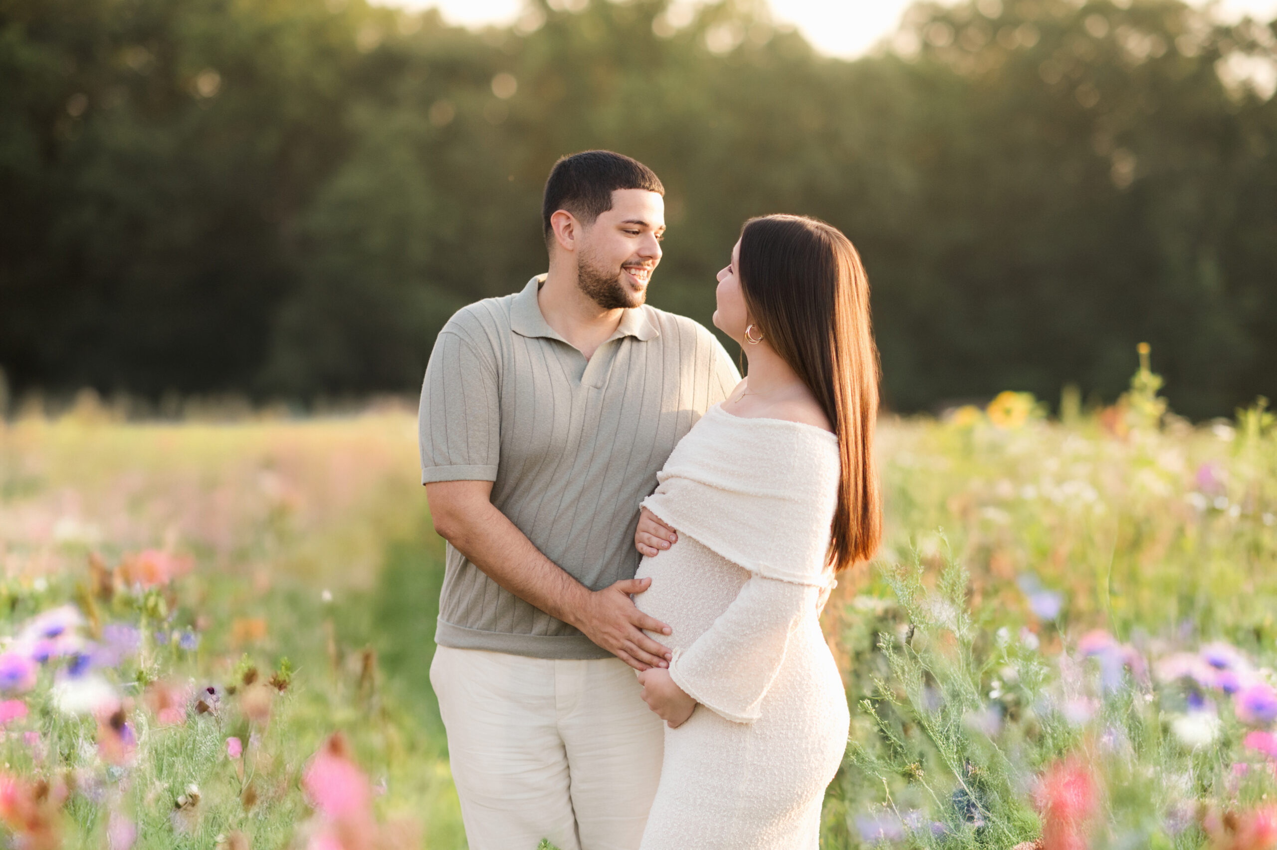 Expecting couple standing in wildflower field at sunset during maternity session in Lancaster, PA