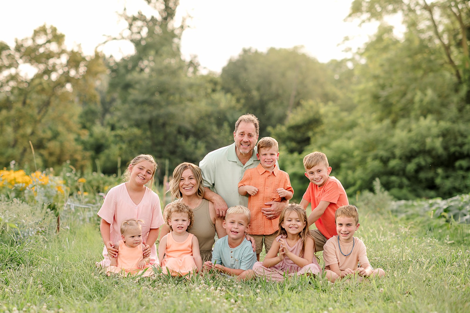Group of grandchildren sitting in a field of flowers during family photos in Lancaster County