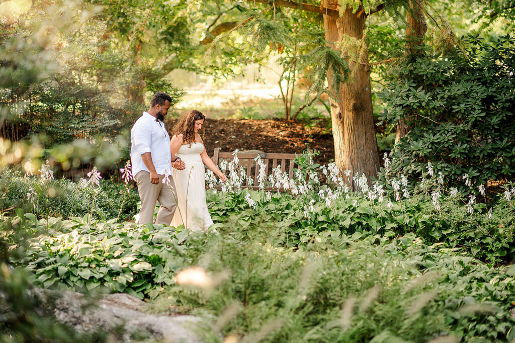 engaged couple walking through flowers during romantic engagement session in Pennsylvania