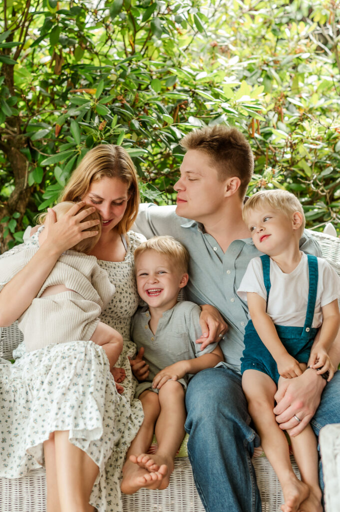 Family sitting close together and laughing during an outdoor Story of Home family photography session by Kara Michelle Photography