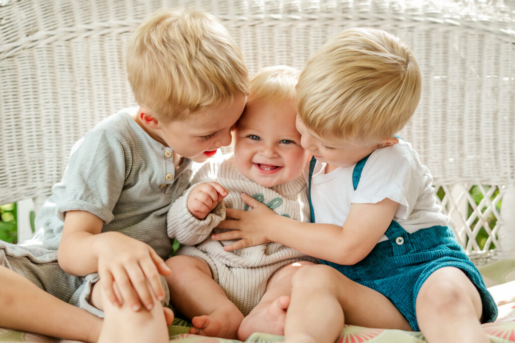 Three siblings cuddling and laughing together during a Story of Home family photography session by Kara Michelle Photography