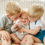 Three siblings cuddling and laughing together during a Story of Home family photography session by Kara Michelle Photography