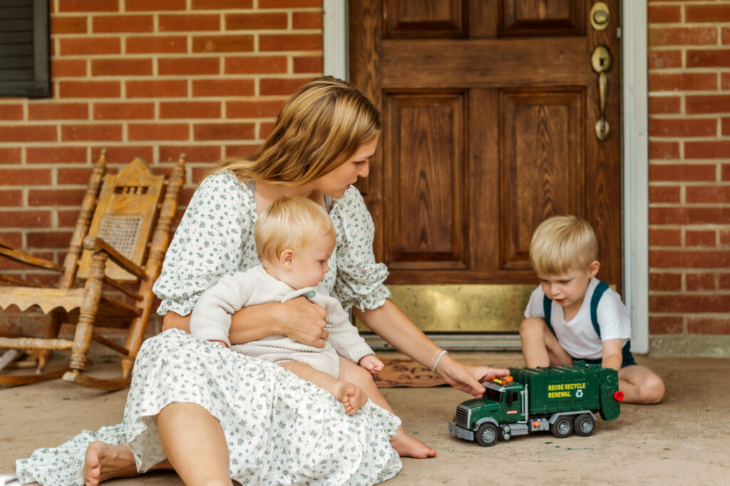 Mother sitting on her front porch playing with her young children during a Story of Home family photography session by Kara Michelle Photography