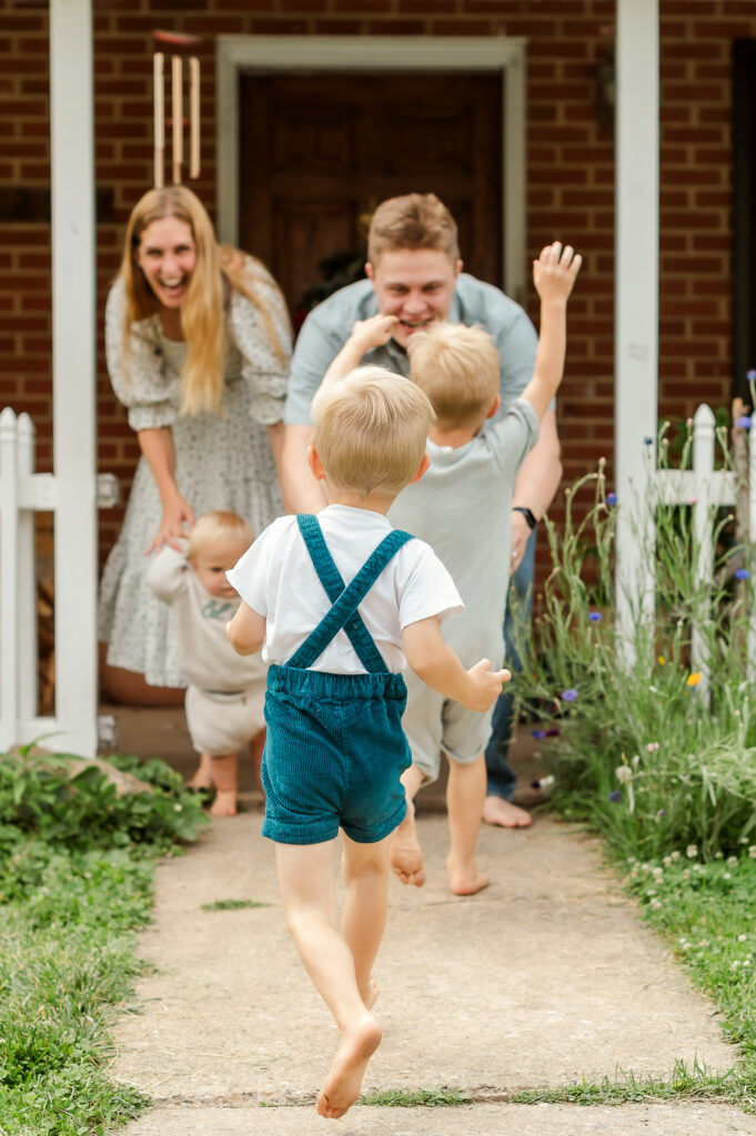 Young children running toward their parents outside their home during a Story of Home family photography session by Kara Michelle Photography