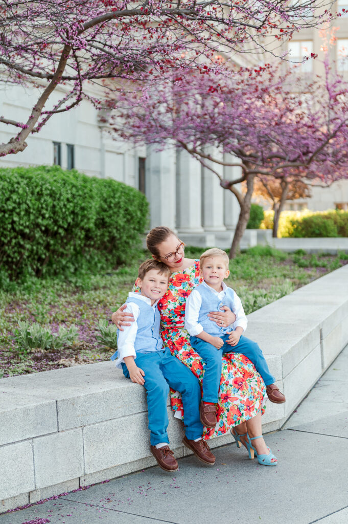 Family with two children sitting under cherry blossom trees during a spring family photo session in York Pennsylvania