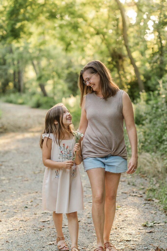 Mother and daughter walking together on a wooded trail during a mommy and me session in York, PA