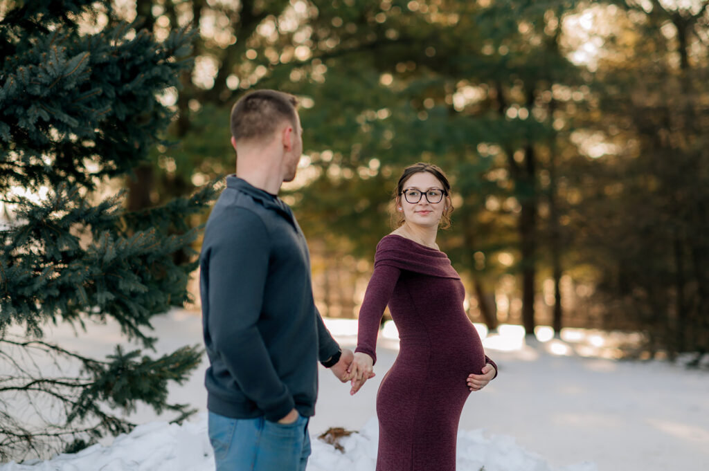 Pregnant couple holding hands during maternity photo session at John Rudy Park.
