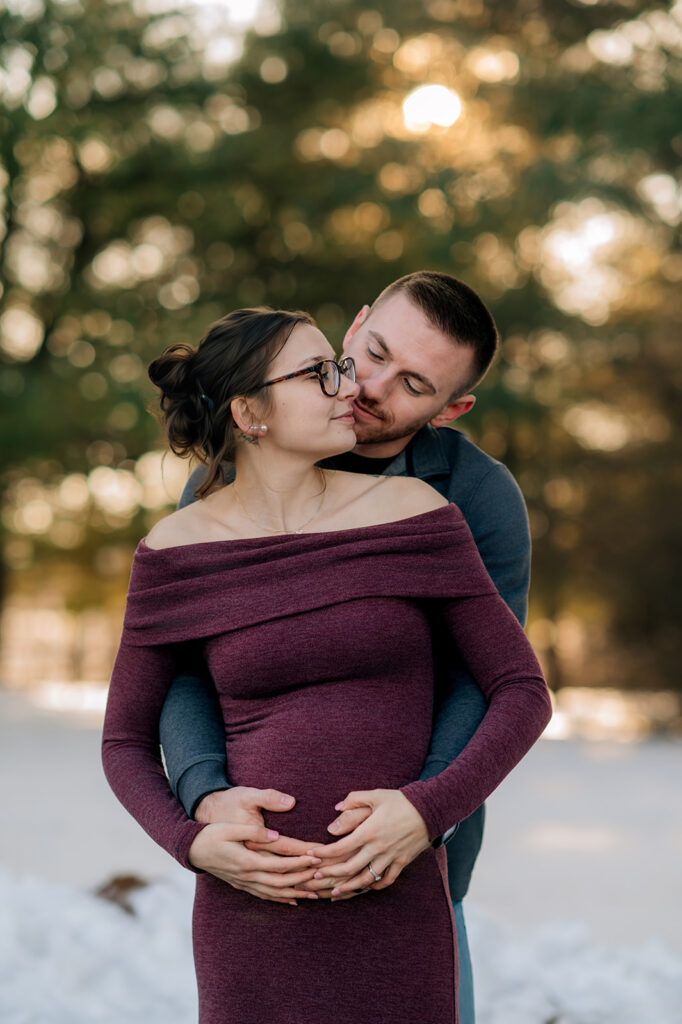 Expecting couple embracing outdoors at sunset in York County Pennsylvania.