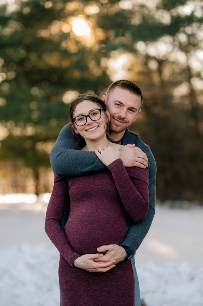 Expecting couple hugging during golden hour pregnancy session in York Pennsylvania.
