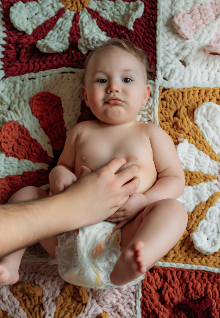 Baby girl lying on a crocheted blanket during a Lancaster baby milestone photography session