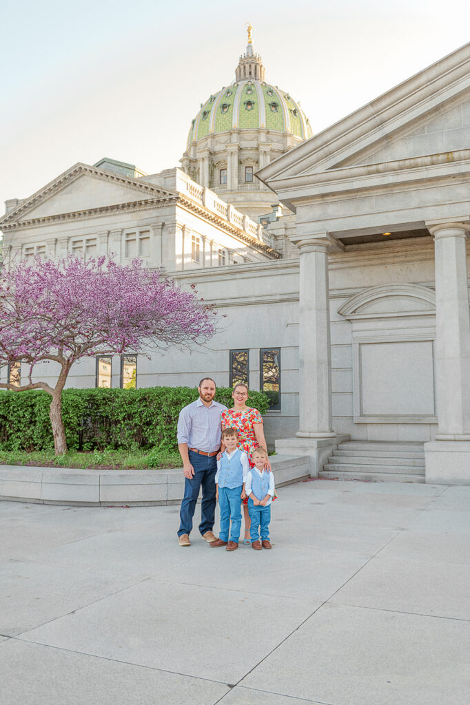 family standing in front of Pennsylvania State Capitol during spring photo session 