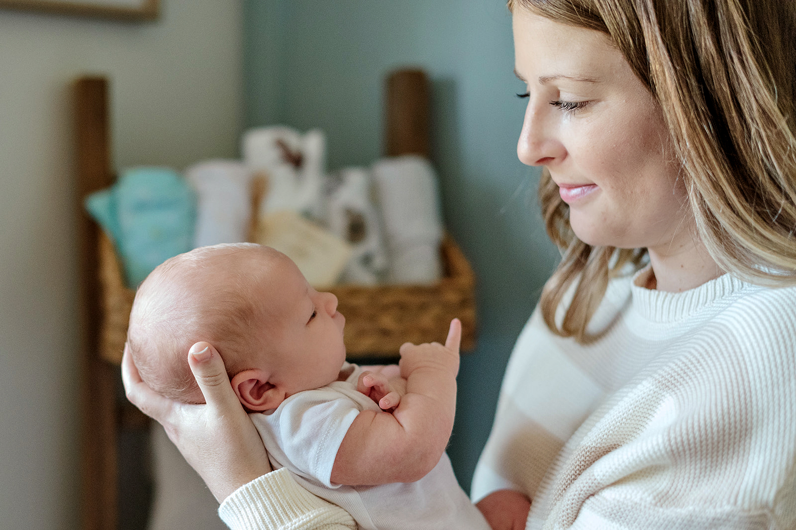 new mom holding her newborn baby during the first week at home