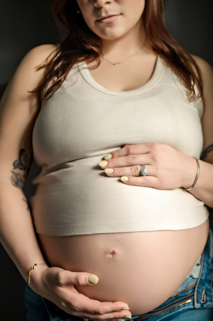 close-up maternity photo of pregnant mother holding baby bump