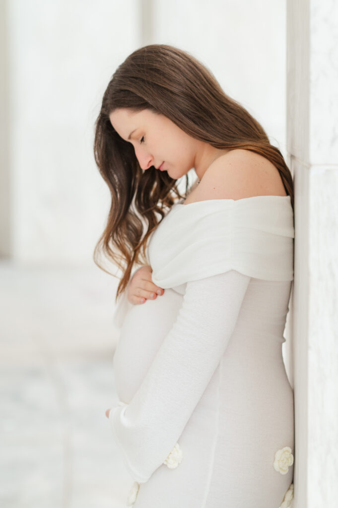 expecting mother in white dress looking down at baby bump maternity photo York PA
