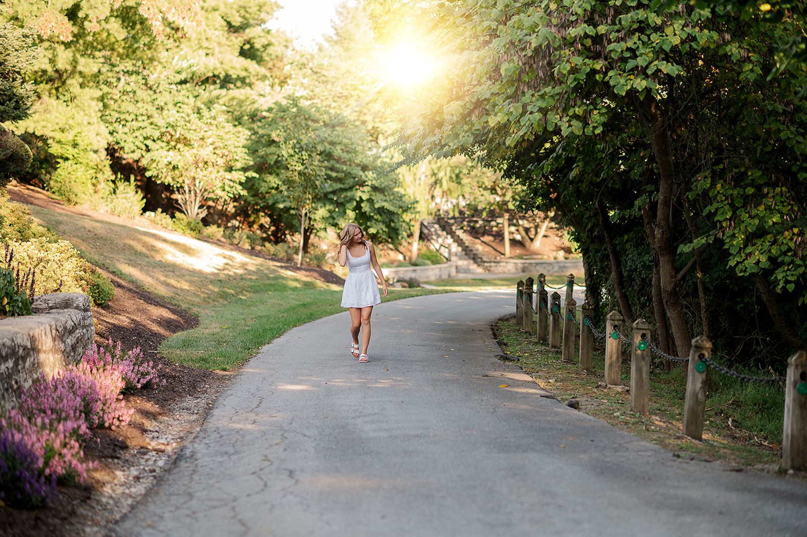 high school senior girl walking along tree lined path during summer photo session in York PA