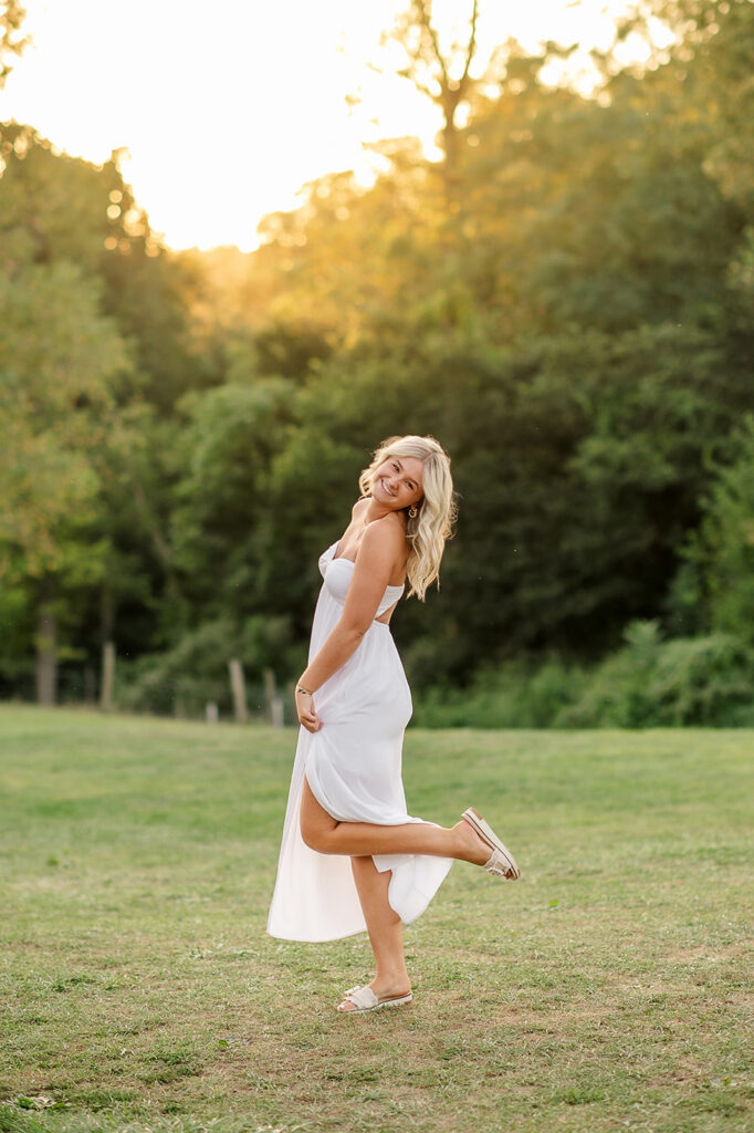 high school senior wearing a flowy white dress during golden hour senior photo session in Lancaster PA