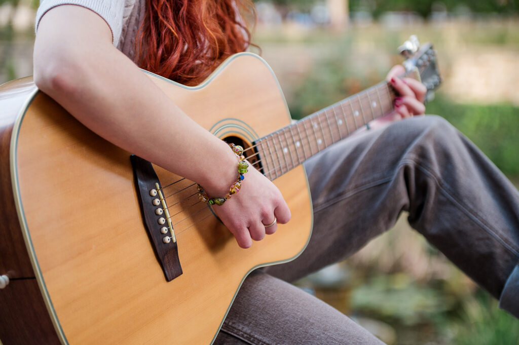 close up of high school senior playing acoustic guitar during senior photo session in York PA