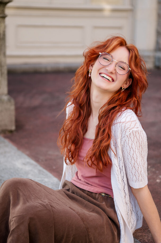 high school senior laughing while sitting on steps during senior photo session in Lancaster PA