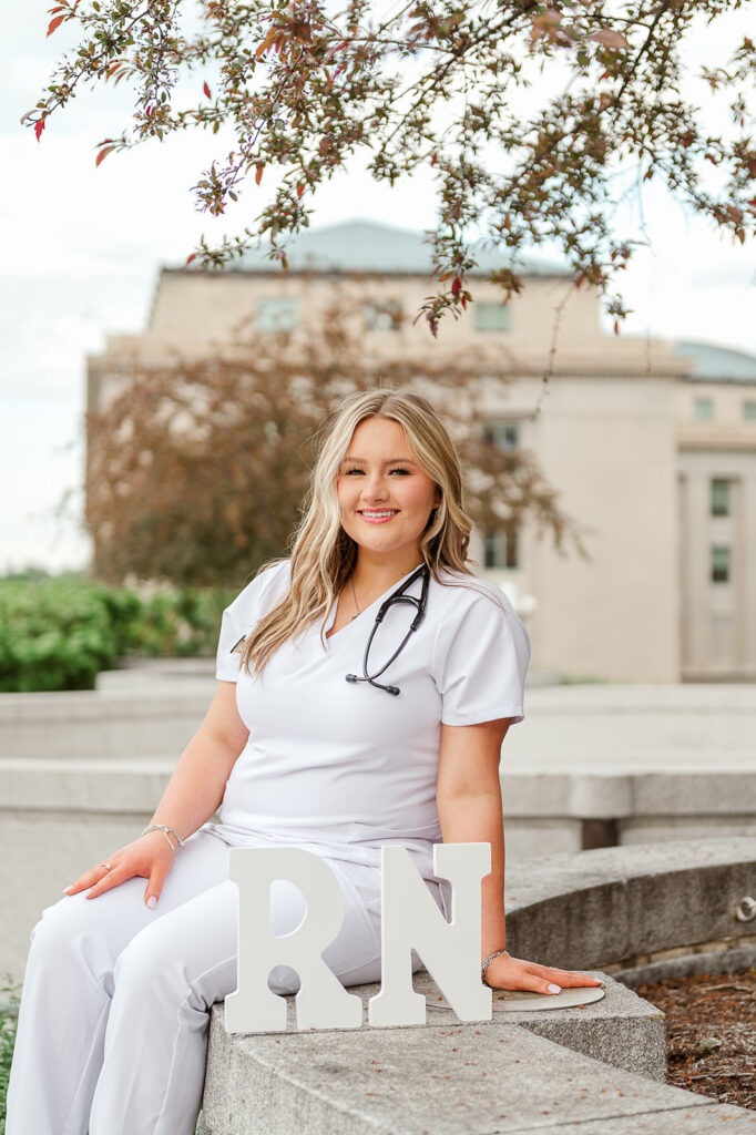 high school senior in nursing scrubs with RN letters during senior photo session in Pennsylvania