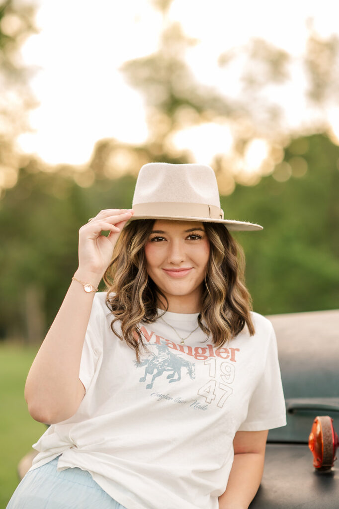 high school senior smiling and holding hat during senior portrait session in Lancaster PA