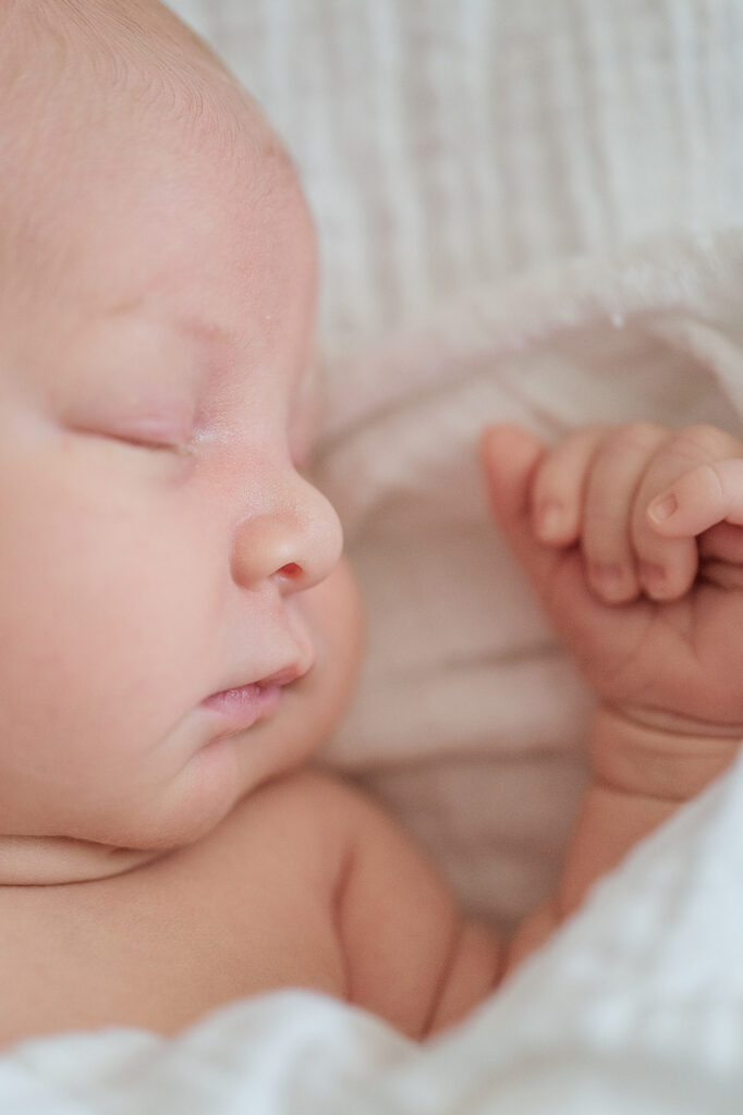 close up of sleepy newborn baby face and tiny eyelashes