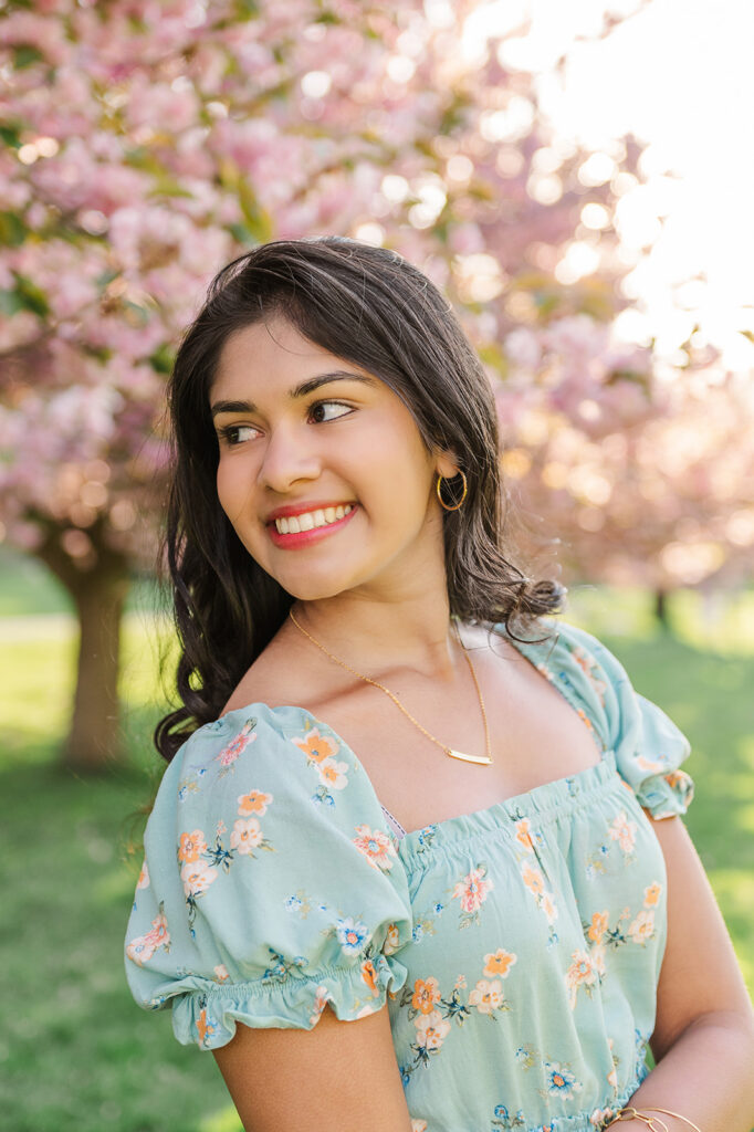 high school senior wearing floral dress during spring senior photo session with blooming trees in Central PA
