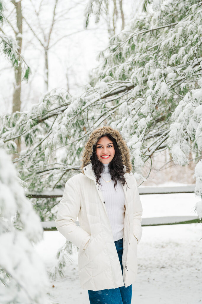 high school senior wearing winter coat during snowy senior photo session in Central PA