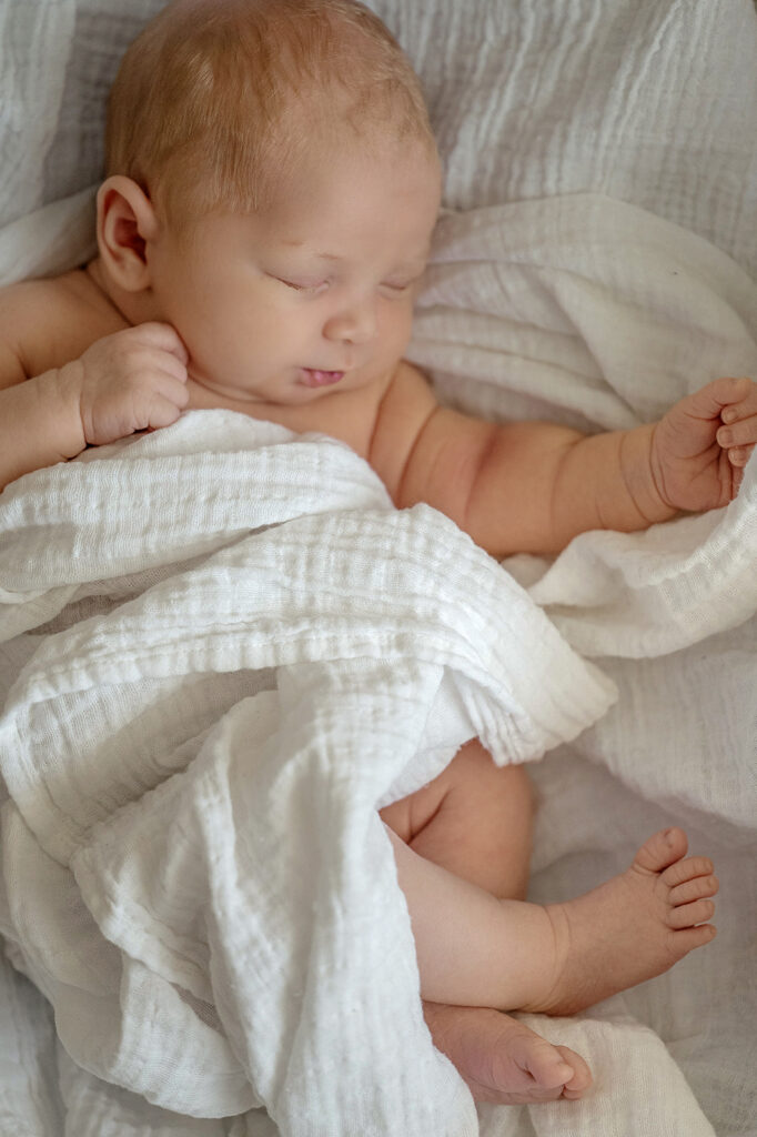 newborn baby wrapped in soft neutral swaddle