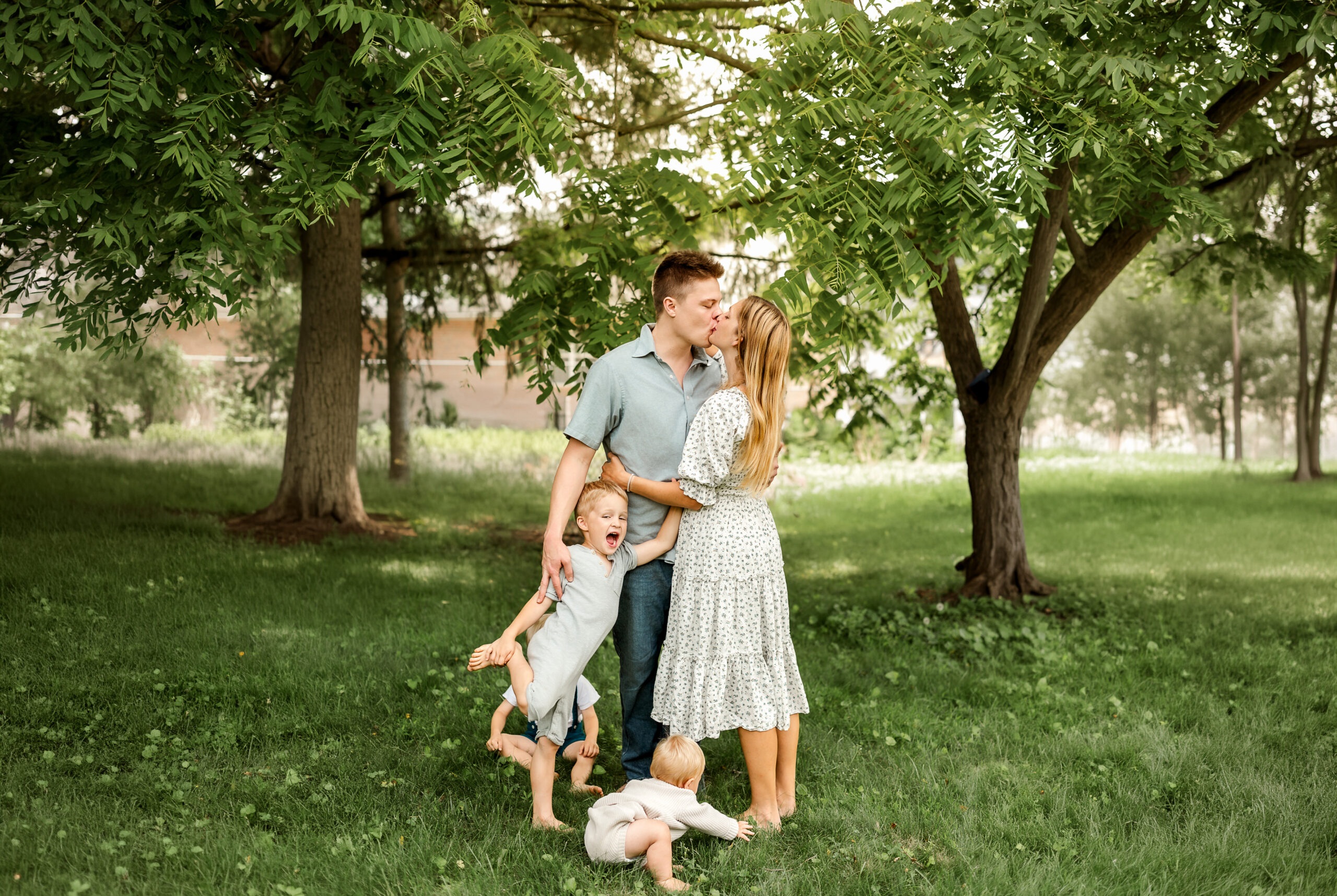 Family sharing a candid moment outdoors while kids play during a photo session in York, PA