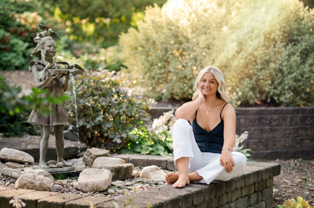senior girl sitting by fountain at hershey gardens