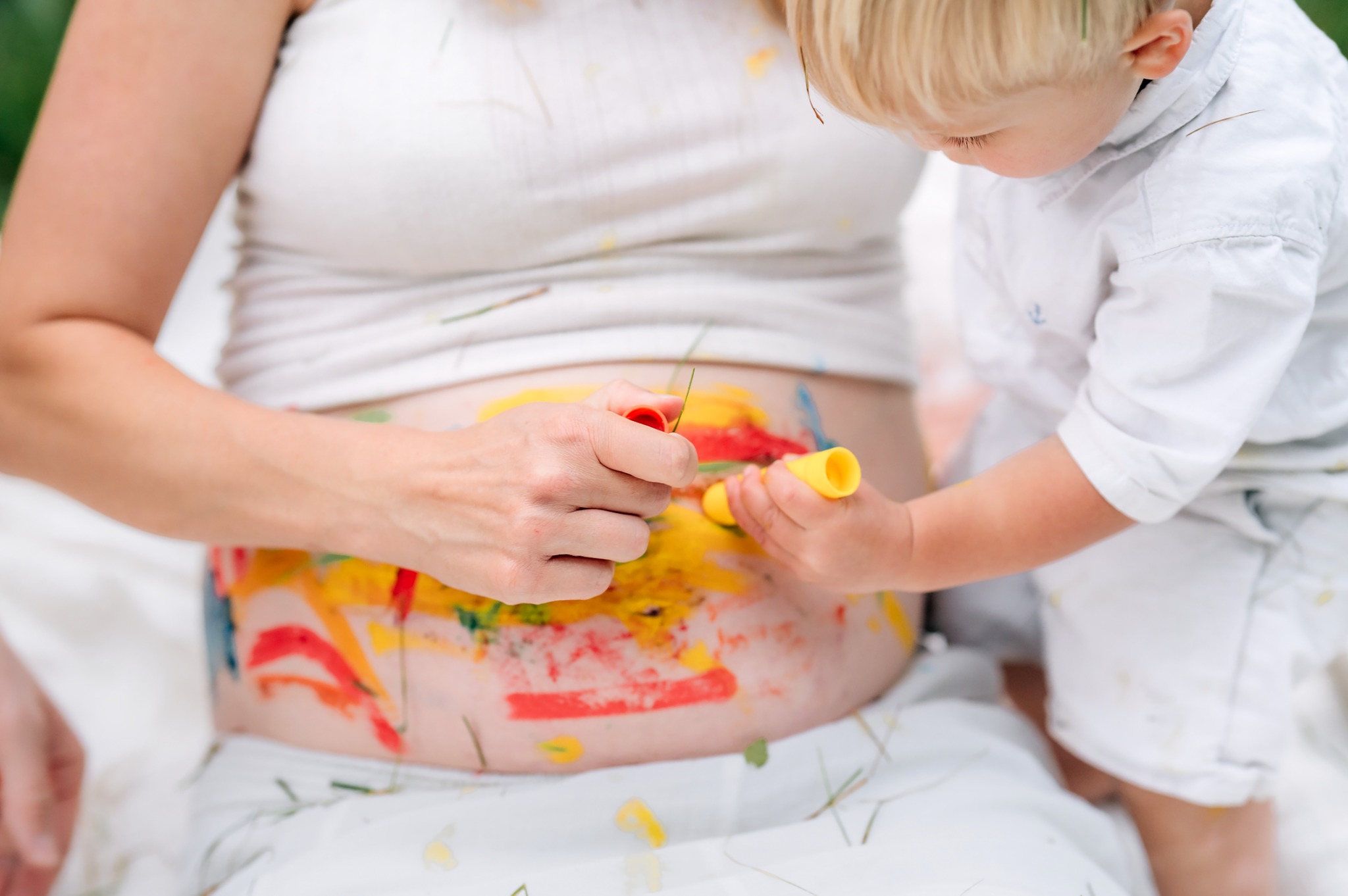children painting on mom's belly for her rainbow baby in york pa
