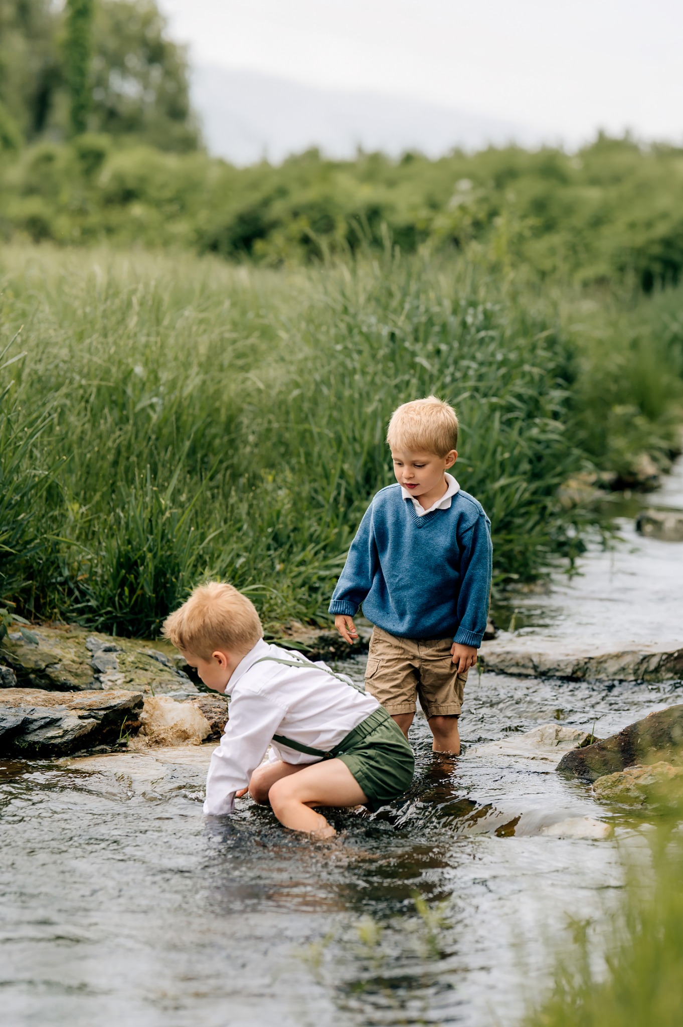 Two brothers playing in a creek during a family maternity session