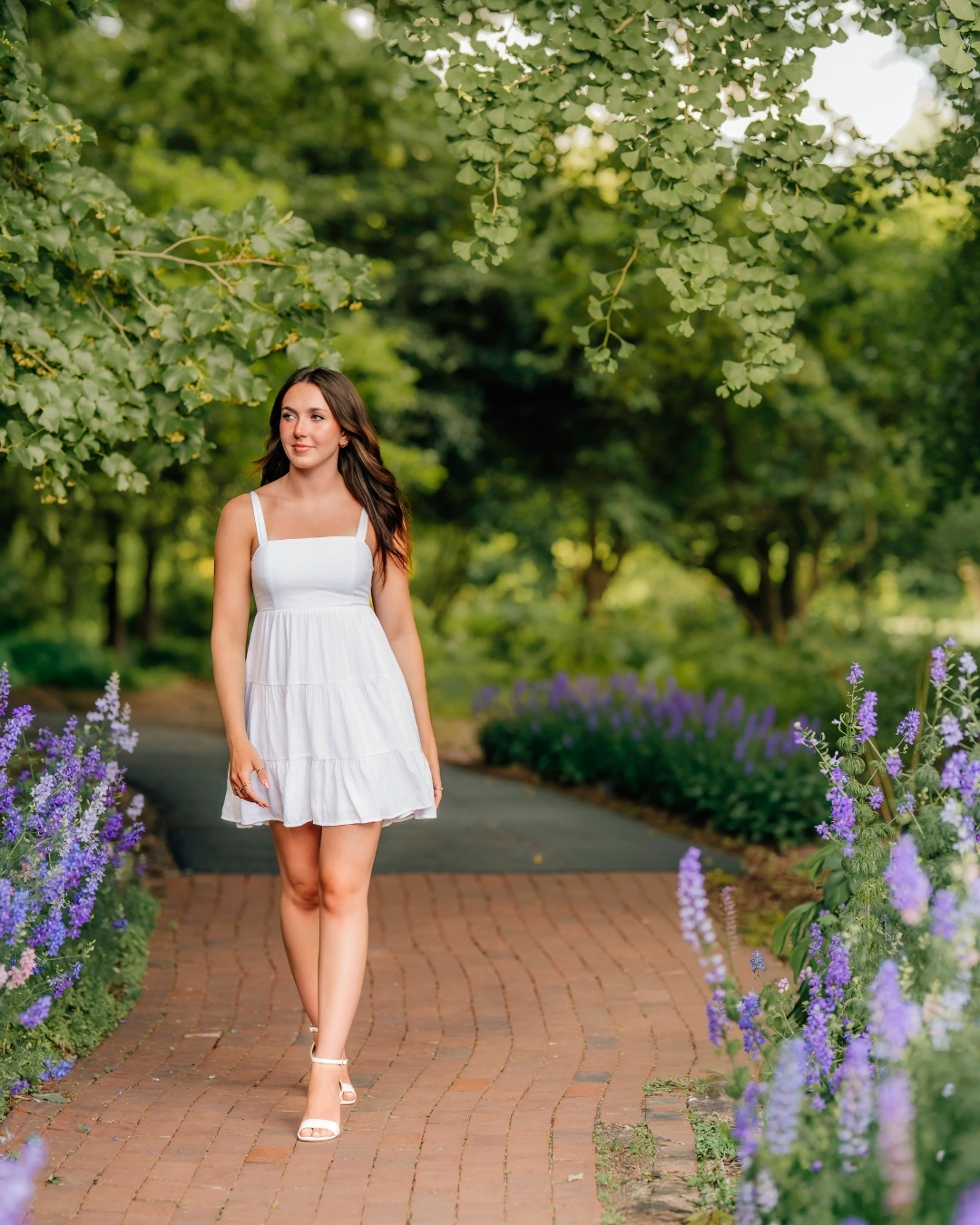 High school senior walking through a flower garden during senior pictures in Lancaster PA