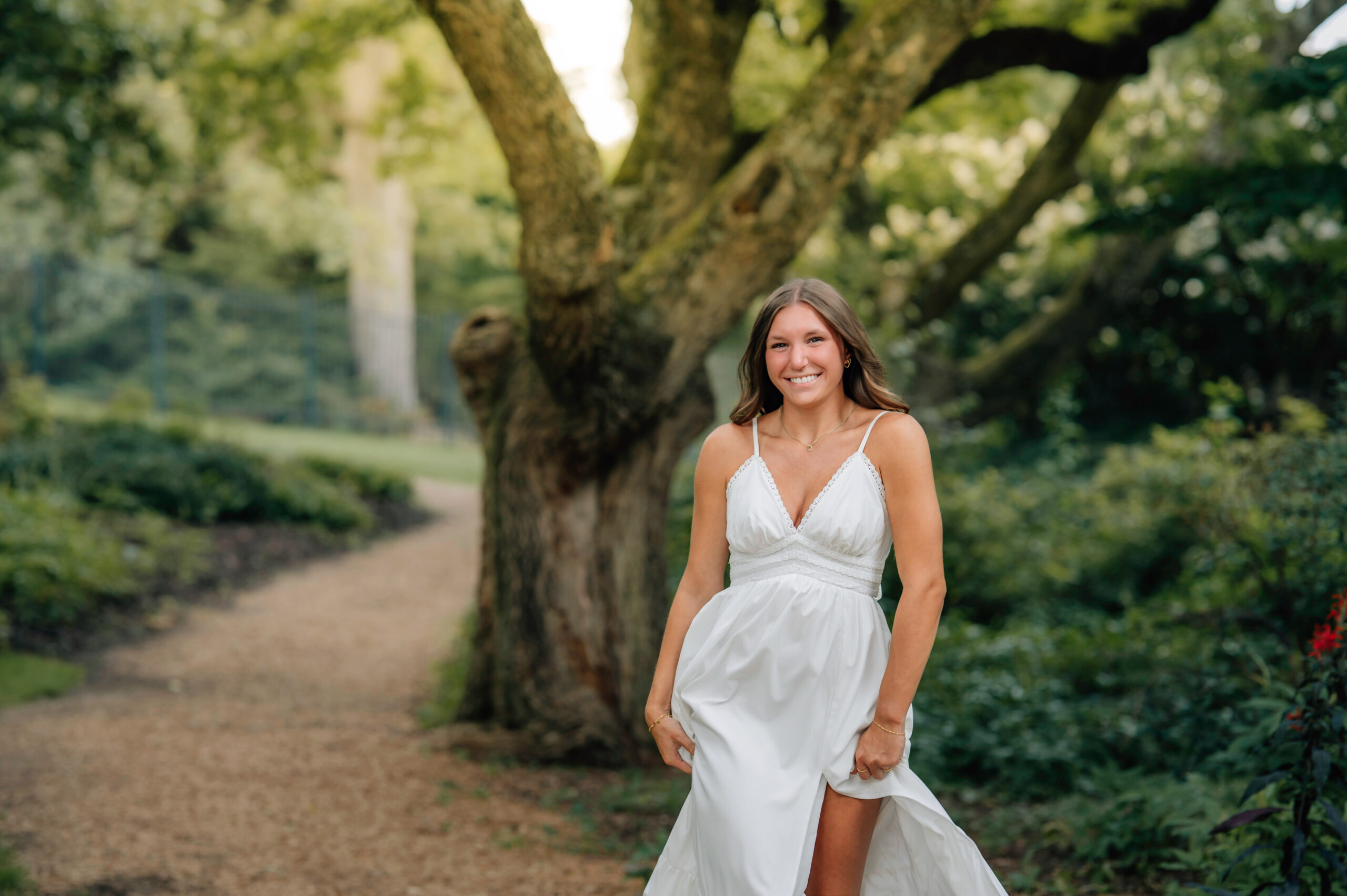 High school senior posing beneath a large tree during outdoor senior pictures in York PA