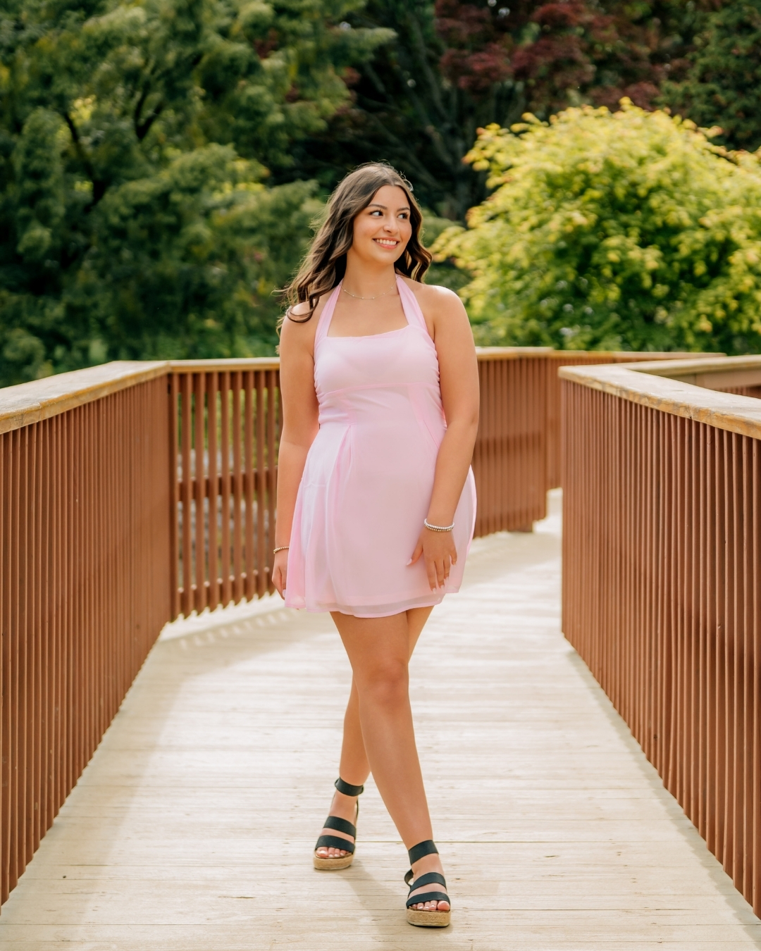 Senior girl wearing a pink dress during outdoor senior pictures in Lancaster PA