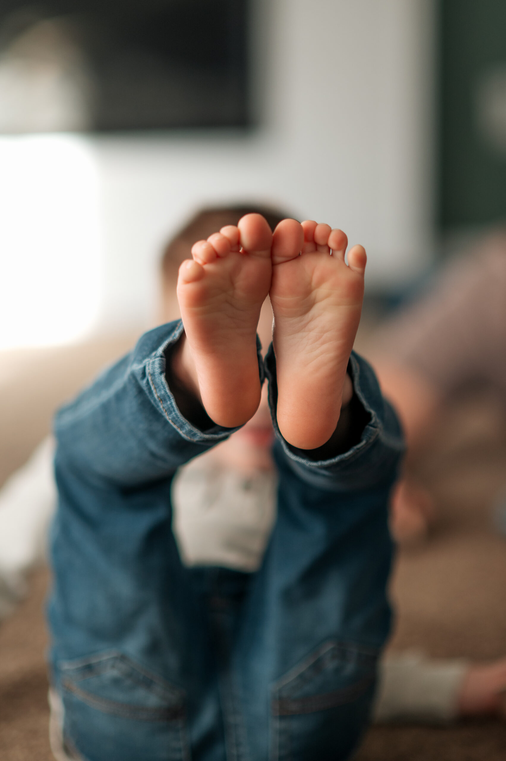 Close-up of a child's bare feet during a documentary family session at home